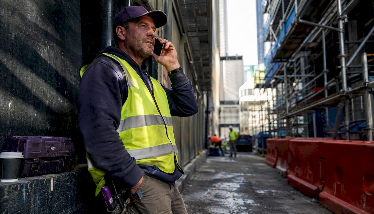 Australian tradie answering voice call at work site