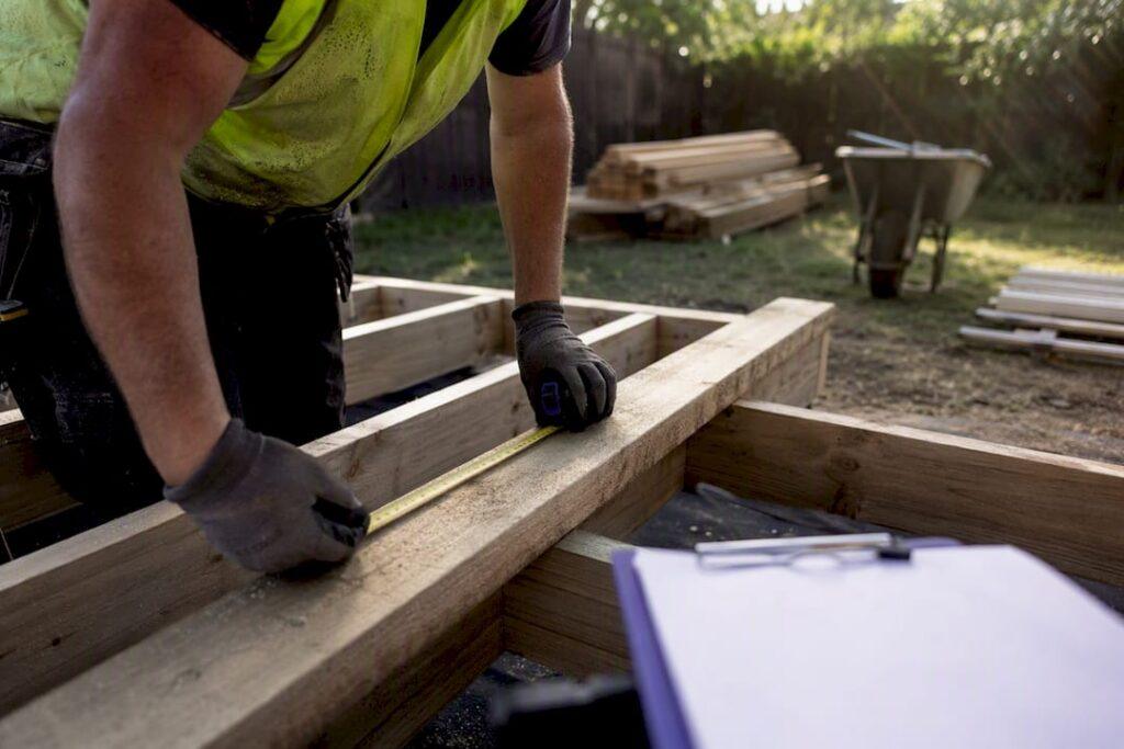 Tradie measuring timber onsite for quote