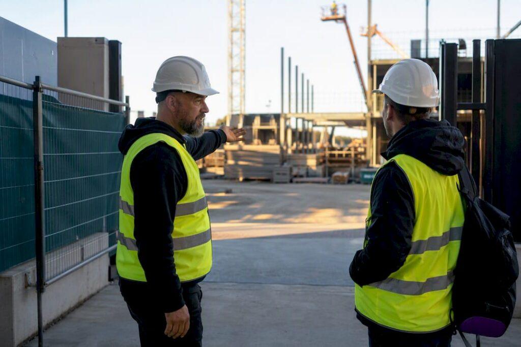 Supervisor briefing worker at construction site entrance