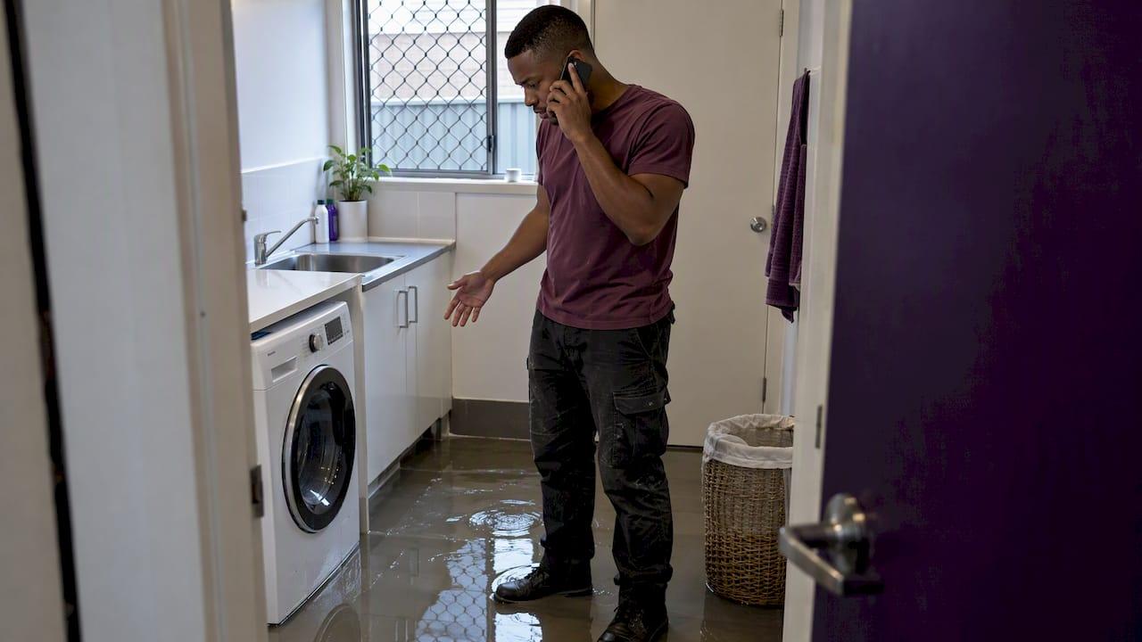 Homeowner calling for help in flooded laundry